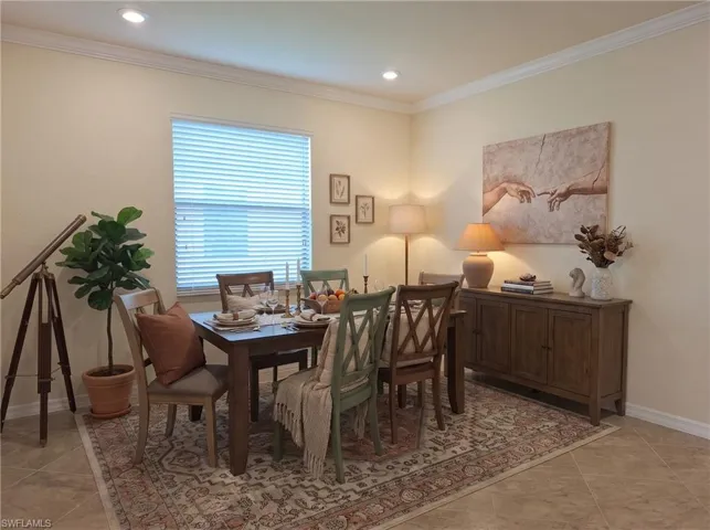 Neutral-toned interior space featuring light-colored tile flooring, crown molding, and recessed ceiling lighting