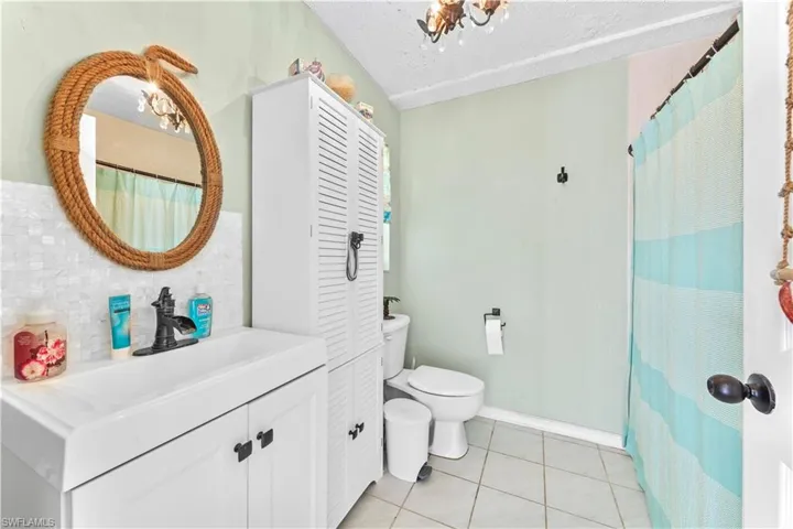 Bathroom featuring toilet, a textured ceiling, vanity, and tile patterned flooring