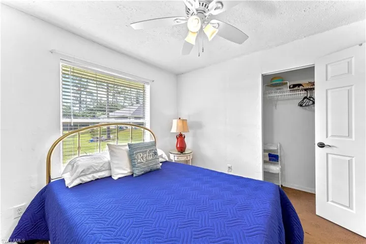 Bedroom featuring a closet, carpet floors, a textured ceiling, and ceiling fan