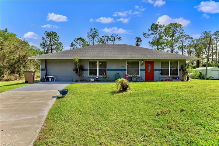 Ranch-style house with a front yard, a garage, and a porch