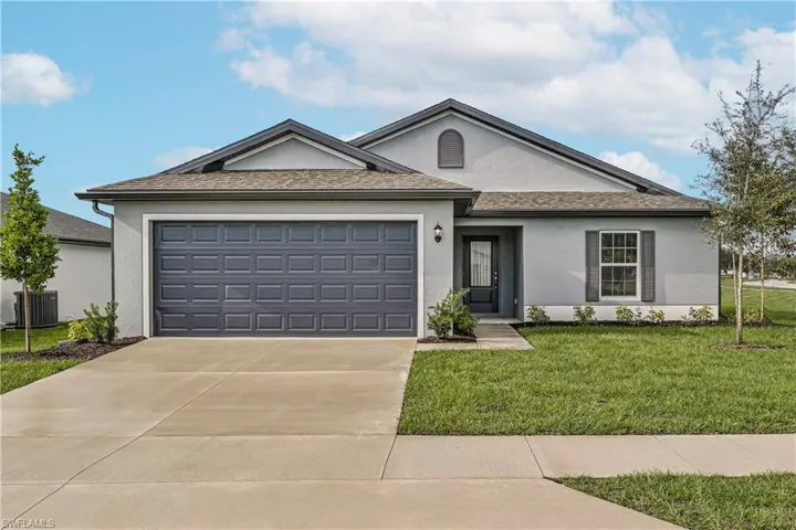 Ranch-style house featuring a garage, a front yard, and central AC unit