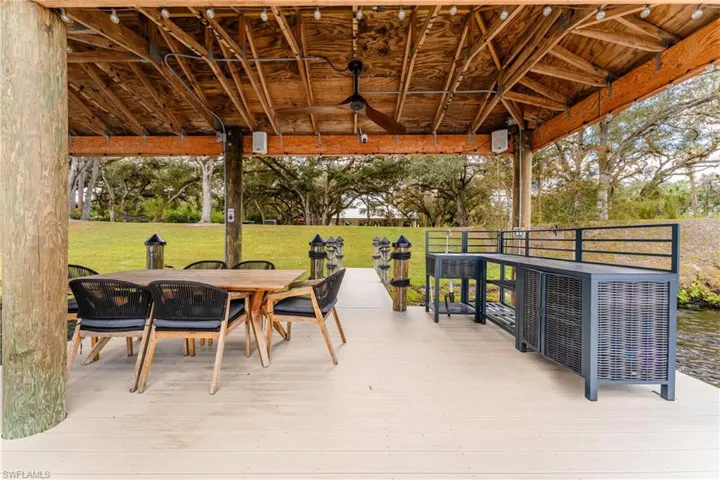 View of patio with a deck with water view, a gazebo, and ceiling fan