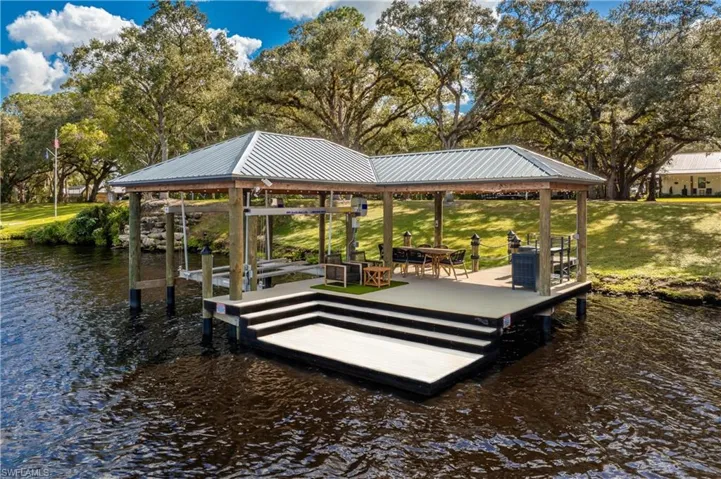 Dock area with a lawn and a water view