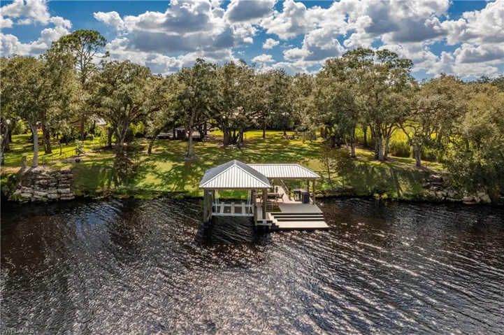 View of dock with a water view and a yard