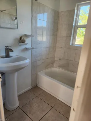 Full bathroom featuring light tile patterned flooring and tub / shower combination