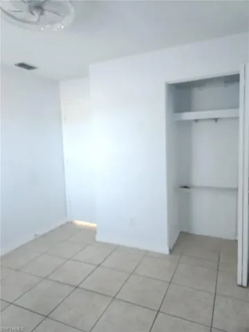 Unfurnished bedroom with a closet and light tile patterned floors
