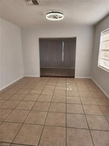 Spare room with light tile patterned floors and a textured ceiling