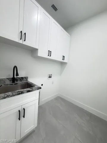 Laundry room with cabinet space, hookup for a washing machine, and hookup for an electric dryer