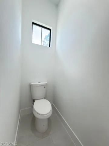 Bathroom with toilet and light tile patterned floors
