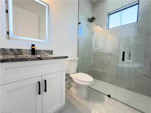 Bathroom featuring vanity and a shower stall