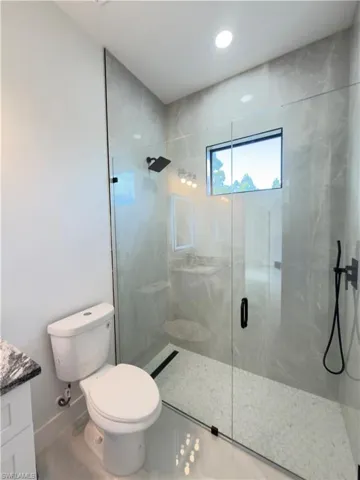 Full bathroom with a marble finish shower and vanity
