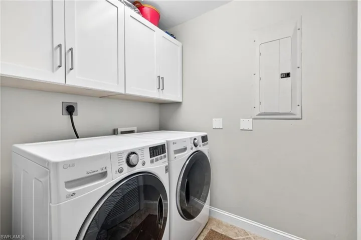 Laundry room featuring cabinet space, electric panel, and washer and dryer