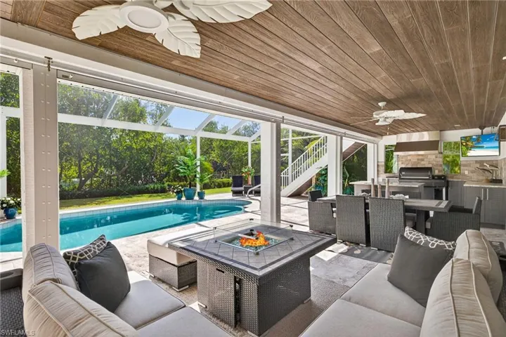 View of patio / terrace featuring ceiling fan, an outdoor kitchen, a fire pit