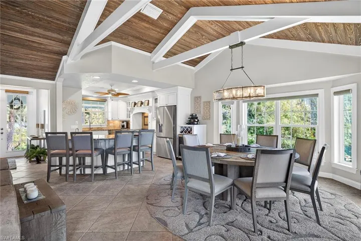 Dining area featuring a high wooden beamed ceiling and light tile patterned floors