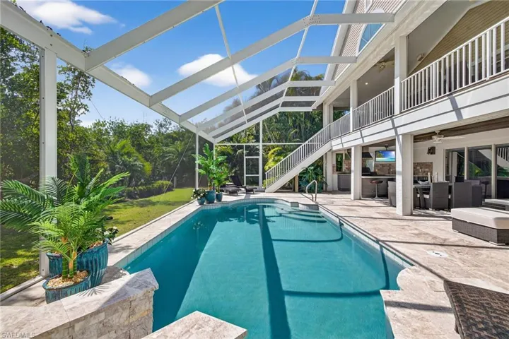 Outdoor pool featuring a patio, a sunroom, a balcony, and outdoor dining area
