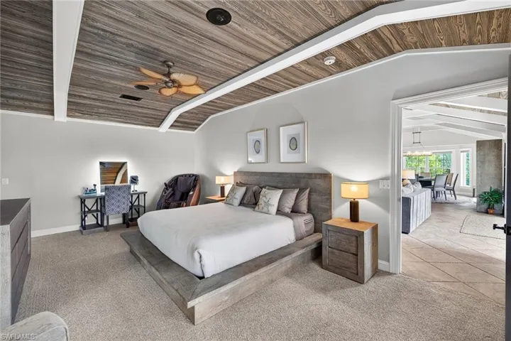 Bedroom with carpet flooring, a ceiling fan, and a vaulted wood ceiling