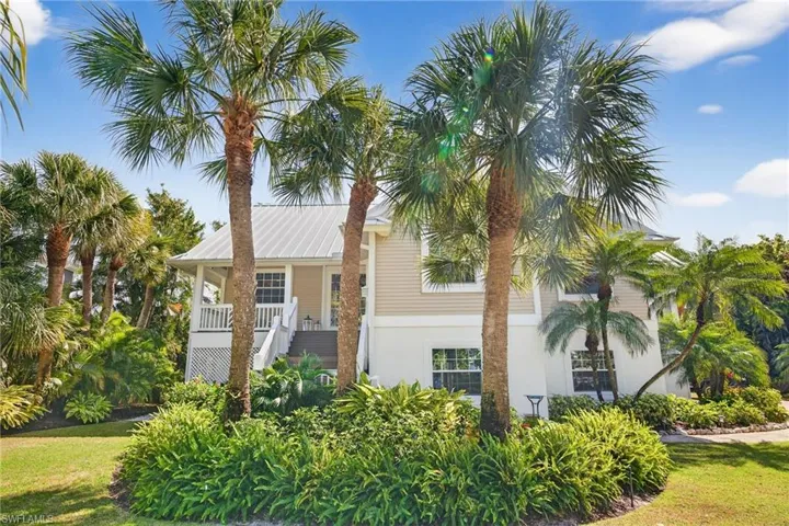 View of front of property featuring a front lawn, stucco siding, and covered porch