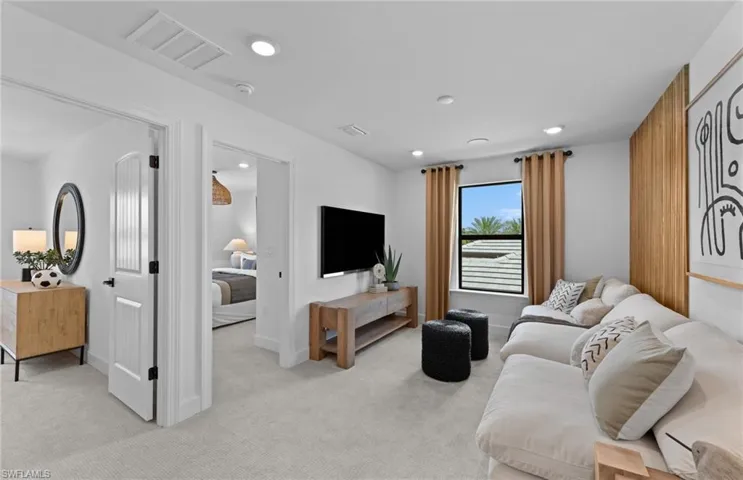 Living area with light colored carpet and recessed lighting
