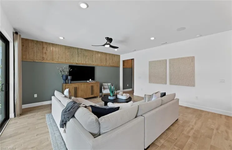 Living area featuring wood tiled floors, ceiling fan, and recessed lighting