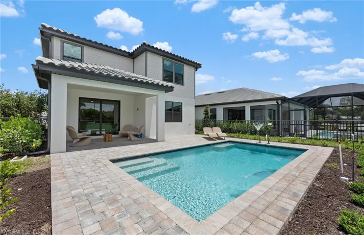 Back of property featuring a patio, a tiled roof, a sunroom, a lanai, and stucco siding