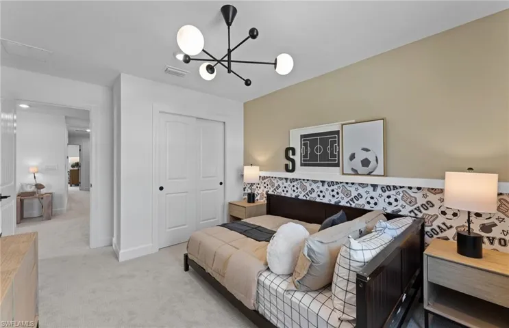 Bedroom featuring a closet, light carpet, and suspended lighting
