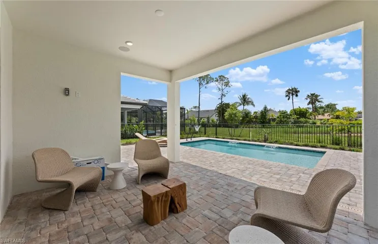 View of swimming pool featuring patio surround, glass enclosure, and a fenced backyard
