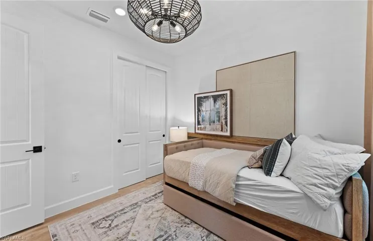 Bedroom with light wood-style floors and a closet