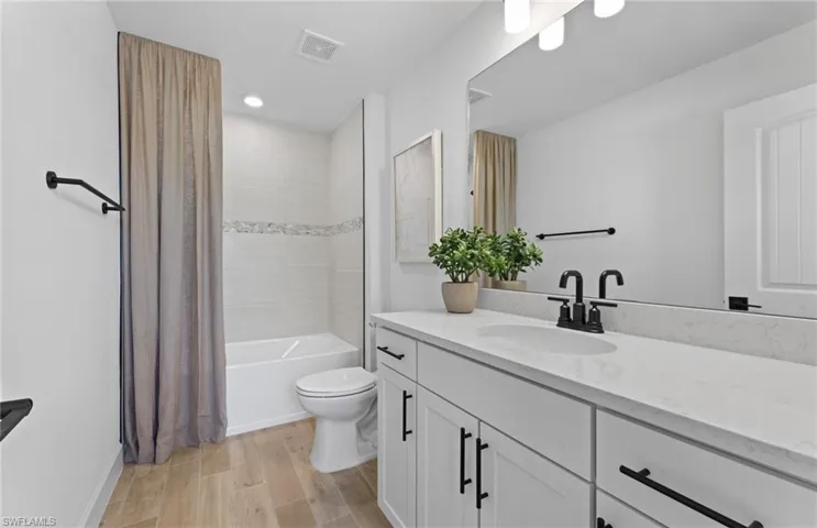 Bathroom with vanity, light wood finished floors, and shower / tub combo