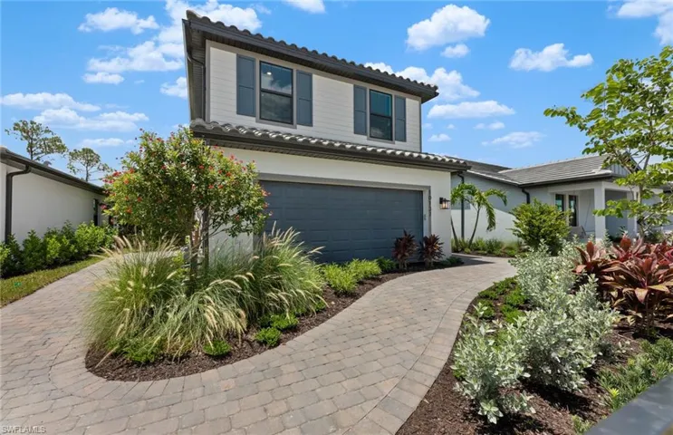 View of front of home with an attached garage, stucco siding, and driveway