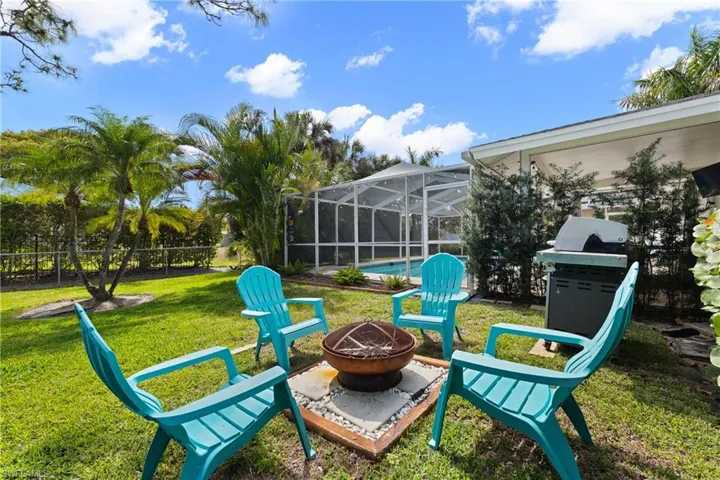 View of patio with glass enclosure, an outdoor pool, an outdoor fire pit, a sunroom, and grilling area