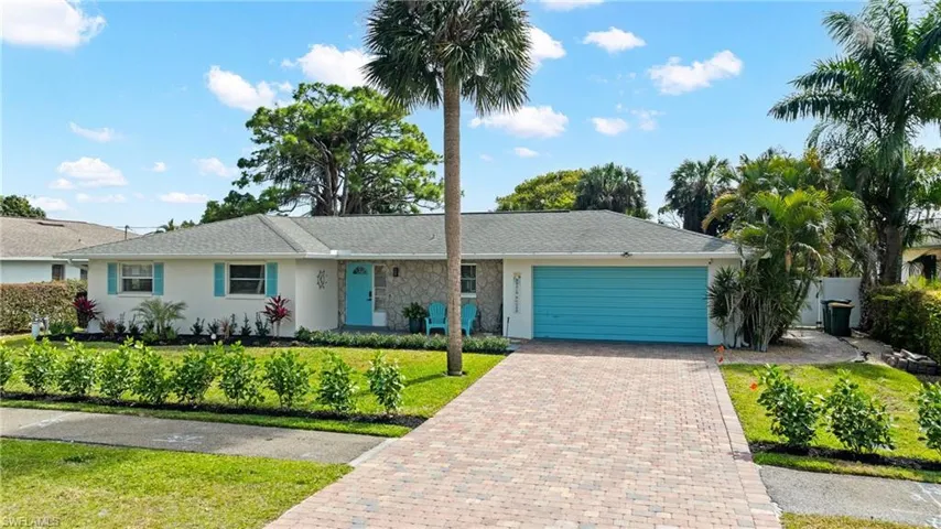 Ranch-style house featuring stucco siding, a garage, decorative driveway, and a front lawn