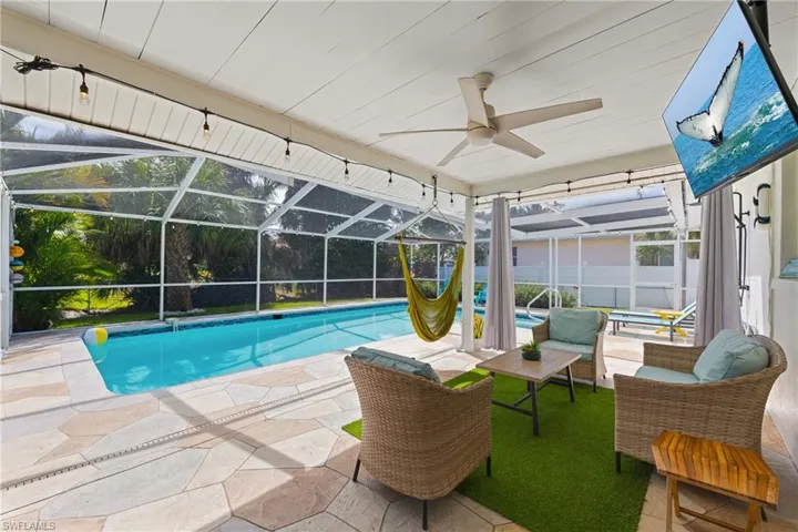Swimming pool with a lanai, a sunroom, a patio, and a hot tub