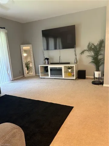 Carpeted living area with baseboards
