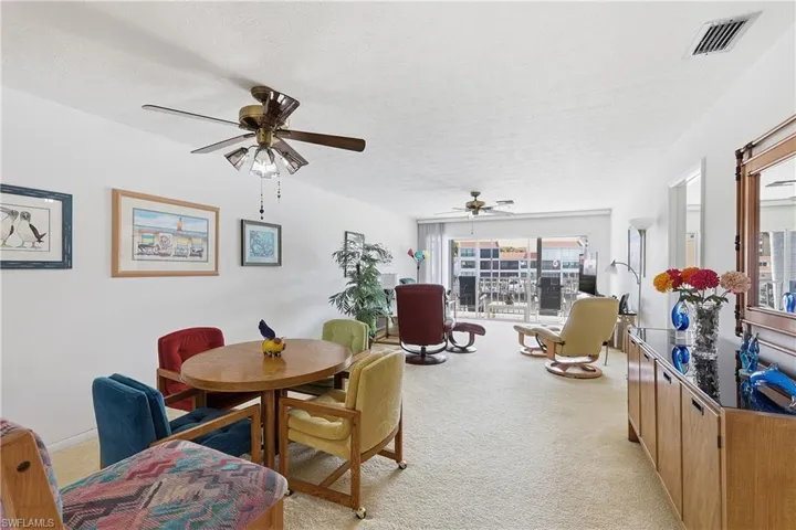 Dining room featuring light carpet, a textured ceiling, and ceiling fan