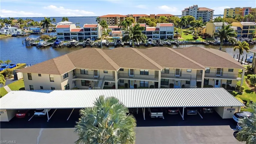 Drone / aerial view of a large body of water and apartment complex / building