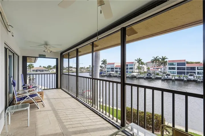 Balcony with a ceiling fan, a water view, and a residential view