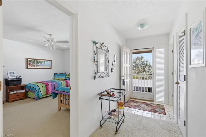 Entryway with light carpet, a textured ceiling, and ceiling fan