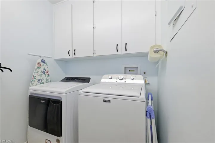 Laundry room featuring separate washer and dryer and cabinet space