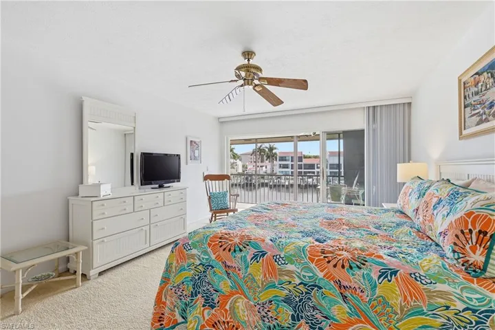 Bedroom with access to outside, a ceiling fan, and light colored carpet