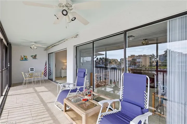 Sunroom / solarium with ceiling fan, a water view, and outdoor dining area