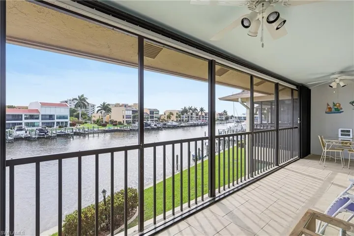 Sunroom featuring a water view and a residential view