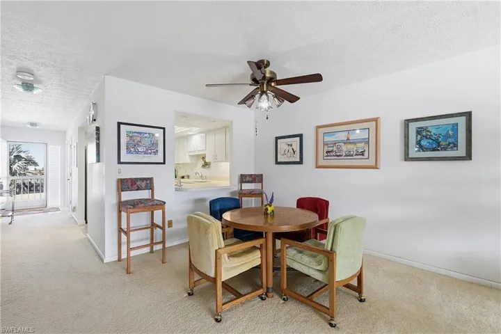Dining room featuring a textured ceiling, light carpet, and ceiling fan