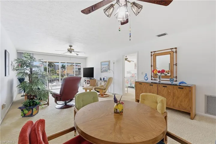 Dining room with light colored carpet and a textured ceiling