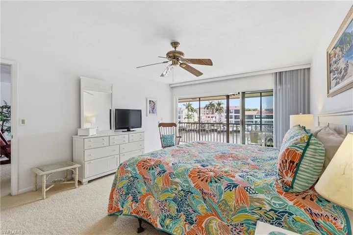Bedroom featuring access to exterior, a ceiling fan, light colored carpet, and a textured ceiling
