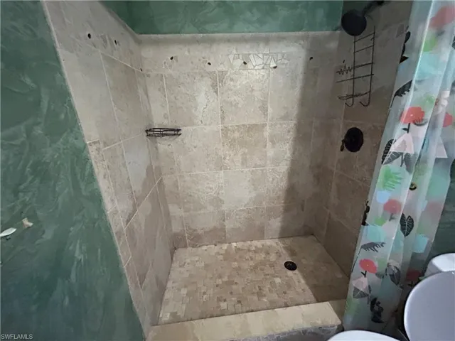 Bathroom featuring a stall shower and toilet