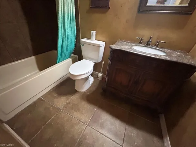 Bathroom featuring vanity, shower / tub combo, and tile patterned floors