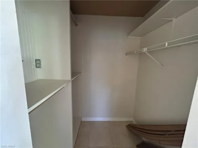 Walk in closet with light tile patterned flooring