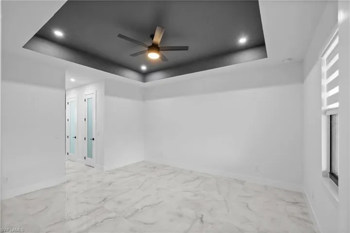 Spare room with a tray ceiling and ceiling fan
