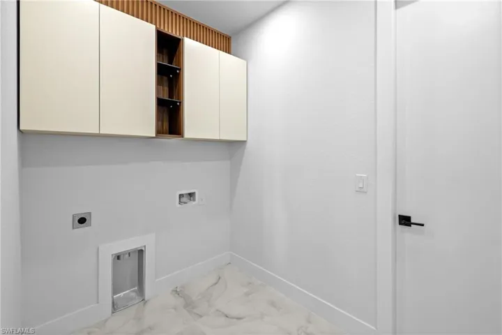 Washroom with cabinets, hookup for an electric dryer, and hookup for a washing machine
