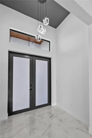 Entryway featuring a towering ceiling and french doors